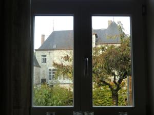 a window with a view of a house and a tree at Bakhuisje 6p nabij Durbuy in Villers-Sainte-Gertrude