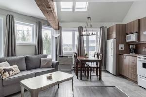 a living room with a couch and a table at Chouette A - Mont-Tremblant in Mont-Tremblant