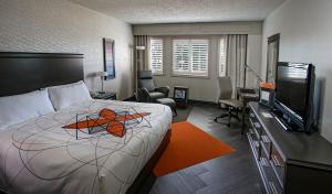 um quarto de hotel com uma cama e uma televisão de ecrã plano em Auberge Godefroy em Bécancour