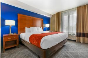 um quarto com uma cama grande e uma parede azul em Comfort Suites Redding - Shasta Lake em Redding