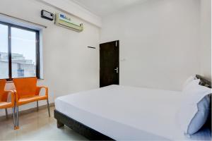 um quarto com uma cama e uma cadeira laranja em Super OYO Hotel Goverdhan Villa em Udaipur