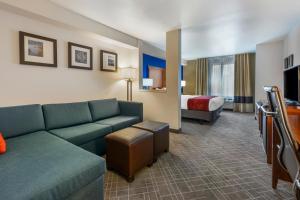 Habitación de hotel con sofá y cama en Comfort Suites Redding - Shasta Lake, en Redding