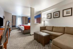 Habitación de hotel con sofá y cama en Comfort Suites Redding - Shasta Lake, en Redding