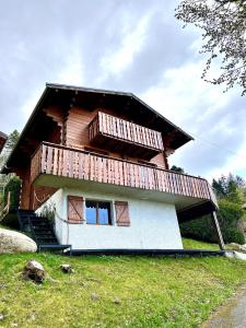 a house with a balcony on top of it at Chalet Mouflon - Vue lac imprenable in Thollon