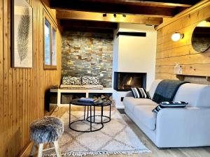 a living room with a couch and a fireplace at Chalet Mouflon - Vue lac imprenable in Thollon