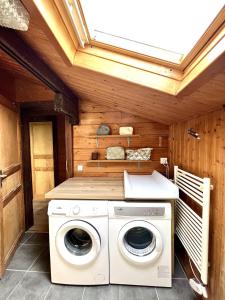 een wasmachine en droger in een houten kamer bij Chalet Mouflon - Vue lac imprenable in Thollon