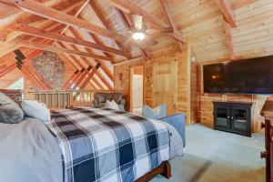 a bedroom with a bed and a flat screen tv at LUX 4BD Lodge w/ Views! Fire Pits + HOT TUB + Pool in Gatlinburg