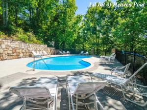 una piscina con un montón de sillas alrededor en LUX 4BD Lodge w/ Views! Fire Pits + HOT TUB + Pool, en Gatlinburg