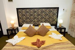 una camera da letto con un grande letto con cuscini di L&D Stay Inn a Hikkaduwa