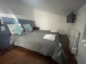 een slaapkamer met een bed met handdoeken erop bij THEIA Hotel & Suites - Limoges Centre in Limoges