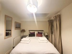 sypialnia z dużym białym łóżkiem z 2 poduszkami w obiekcie Edinburgh 2-Bedroom Cottage with Parking - Ground Floor w Edynburgu