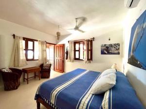 a bedroom with a blue bed in a room at Casa Tom Tom in Holbox Island