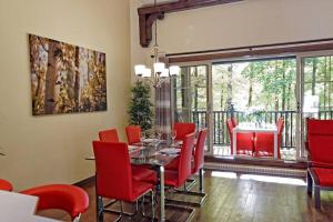 une salle à manger avec une table et des chaises rouges dans l'établissement Manoir B - Mont-Tremblant, à Mont-Tremblant