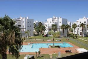 a large swimming pool in a park with buildings at 2-Bed Penthouse Apartment in Roldán
