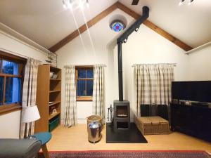 a living room with a stove in a room at Edinburgh 2-Bedroom Cottage with Parking - Ground Floor in Edinburgh