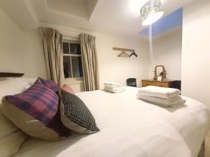 a bedroom with a white bed with towels on it at Edinburgh 2-Bedroom Cottage with Parking - Ground Floor in Edinburgh