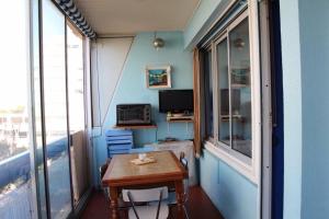 ラ・グランド・モットにあるBleu Soleilのテーブルと窓が備わる小さな客室です。
