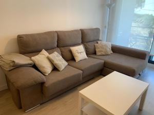 een bruine bank in een woonkamer met een tafel bij Acogedor apartamento en Baiona in Baiona