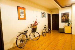 twee fietsen geparkeerd tegen een muur in een gang bij Y Hotel in Kota Kinabalu