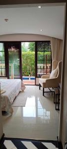 ein Schlafzimmer mit einem Bett, einem Sofa und Fenstern in der Unterkunft Venetian Signature Condo Resort Pattaya in Jomtien Beach