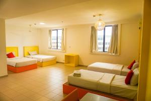 een hotelkamer met 2 bedden en 2 ramen bij Y Hotel in Kota Kinabalu