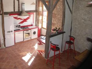 a kitchen with two red chairs and a refrigerator at La tour du guet in Arouille