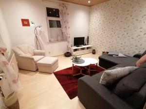 a living room with a couch and a table at FeWo in Nähe zum Sachsenring am Fuße zum Erzgebirge in Gersdorf