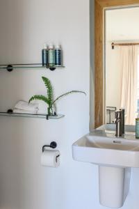 a white bathroom with a sink and a mirror at WITHIN THE VILLAGE in Galway