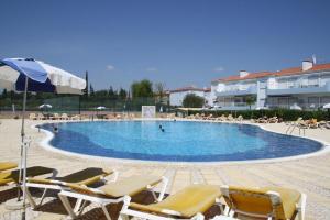 una piscina con sedie e persone in un resort di Luxury 4 bed villa with private pool Oasis Parque, Alvor AT16 a Portimão