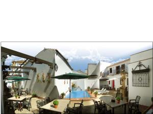 a courtyard with a pool and tables and chairs at Apartamentos La Ciudad in Ronda