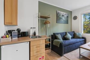 a kitchen and living room with a blue couch at Vorstadtoase - 3 Personen - Apartment mit Queensize-Bett, Badewanne, Schlafcouch, Parken, Netflix, Nähe BER in Eichwalde