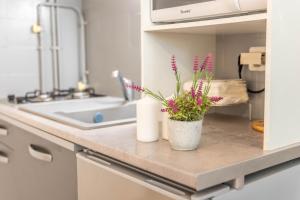 - un comptoir de cuisine avec un vase de fleurs dans l'établissement Les Marines Port 2 Min Plage Camargue- TOP PROS SERVICES Conciergerie La Grande Motte, à Mauguio 28 autres photos