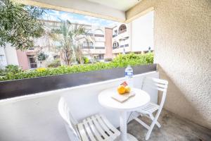 une table avec des chaises, une bouteille d'eau et des fruits sur un balcon dans l'établissement Les Marines Port 2 Min Plage Camargue- TOP PROS SERVICES Conciergerie La Grande Motte, à Mauguio