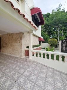 a porch of a house with a balcony at SDQ Villa Isabel, NO FUMAR, cerca embajada EEUU in Santo Domingo