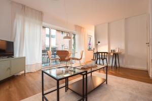 een woonkamer met een glazen tafel en stoelen bij Wohnung mit Tiefgarage u. Balkon in Paderborn