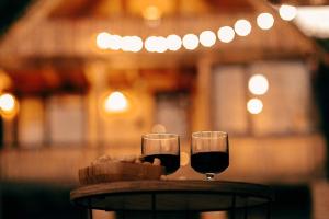 dwa kieliszki wina siedzące na stole w obiekcie Cottage Racha Rhymes w mieście Ambrolauri