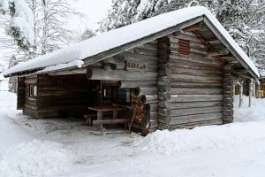 a log cabin with snow on top of it at Classic Log Cabin Ski-in Ski-out in Levi