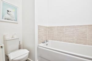 a bathroom with a white tub and a toilet at StayRight 2 Bedroom Flat with Private Parking on Waterfront in Barry