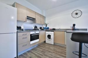 a kitchen with a white refrigerator and a dishwasher at StayRight 2 Bedroom Flat with Private Parking on Waterfront in Barry