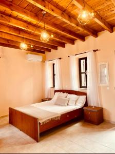 een groot bed in een kamer met houten plafonds bij Pavlos House in Symi
