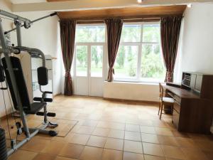 un gimnasio con cinta de correr, escritorio y ventana en Le grand bidot en Louer