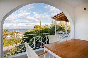 a dining room with a table and a view of the ocean at Peroulia Beach Houses in Koroni