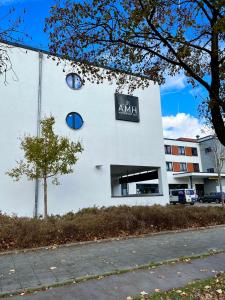 een wit gebouw met een bord aan de zijkant bij AMH - Wohnen auf Zeit in München