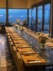 a long table with wine glasses and flowers on it at Hotel De Cielo in Tupungato