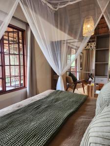 a bedroom with a bed with a canopy at Amare Cabin in the bush with all your needs! in Marloth Park