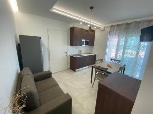 a living room with a couch and a table and a kitchen at Appartamenti Dreams in Marotta