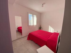 a white room with a red bed and a mirror at Appartamenti Dreams in Marotta