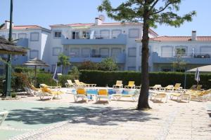 a resort with chairs and a pool and a building at 2 Bedroom Top Floor Apartment, Oasis Parque, near Alvor AT01 in Portimão