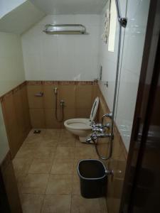 a small bathroom with a toilet and a sink at Hosteller's in Varkala