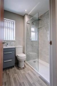 ein Bad mit einem WC und einer Glasdusche in der Unterkunft SUPER 5 Bedroom House Sleeps 11! in Hull